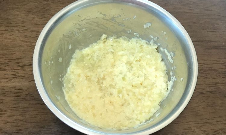 生パン粉・牛乳・とき卵の中に、炒めた玉ねぎを混ぜた画像